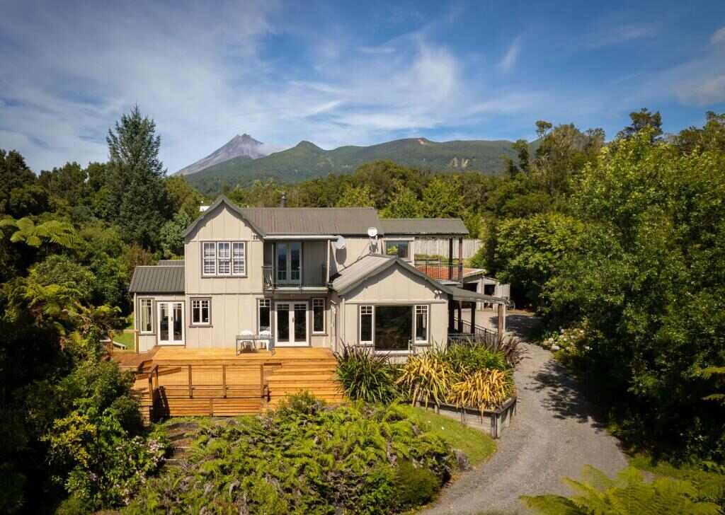 Aerial view of the retreat surrounded by native bush with Mount Taranaki in the distance